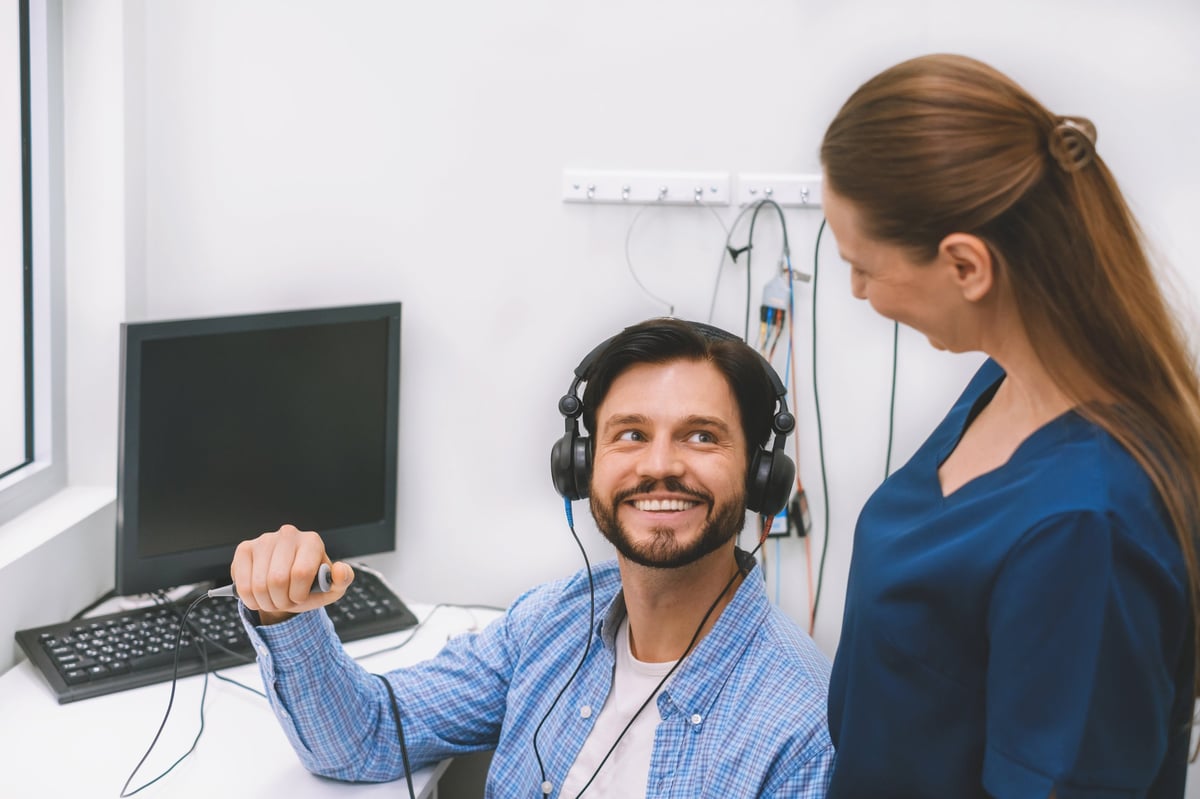 Audiologist conducts a hearing test using headphones in a modern clinic