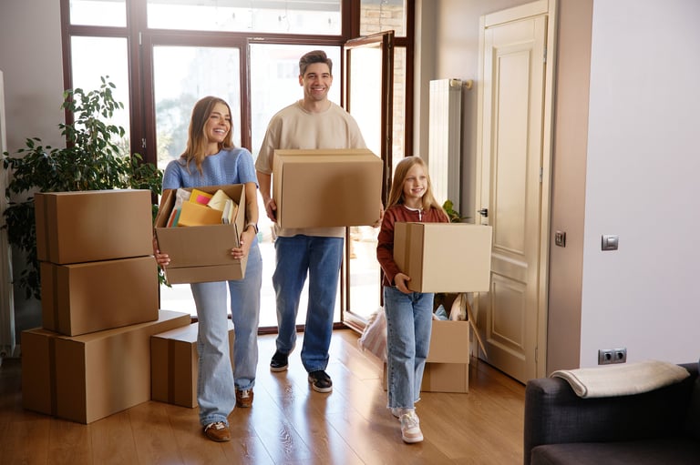 Familie packt gemeinsam lächelnd Umzugskartons in der Wohnung — Teamwork und Vorfreude auf den Neuanfang
