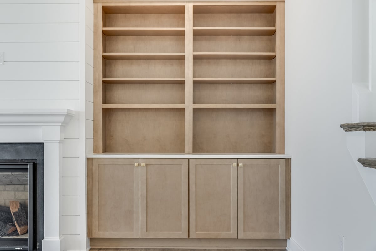 A built-in cabinet with shelving above it