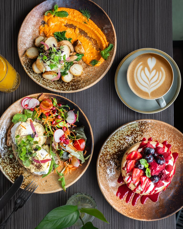 Reichhaltiges Frühstück mit Pancakes und Latte Art