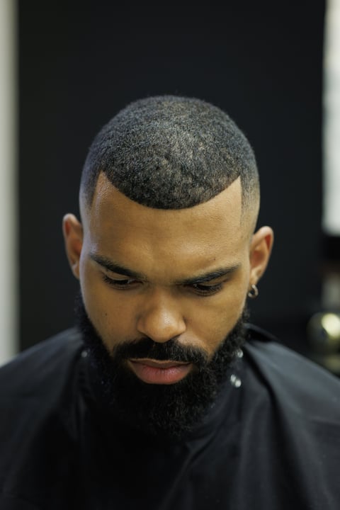 Portrait of african american man with haircut sitting in barbershop