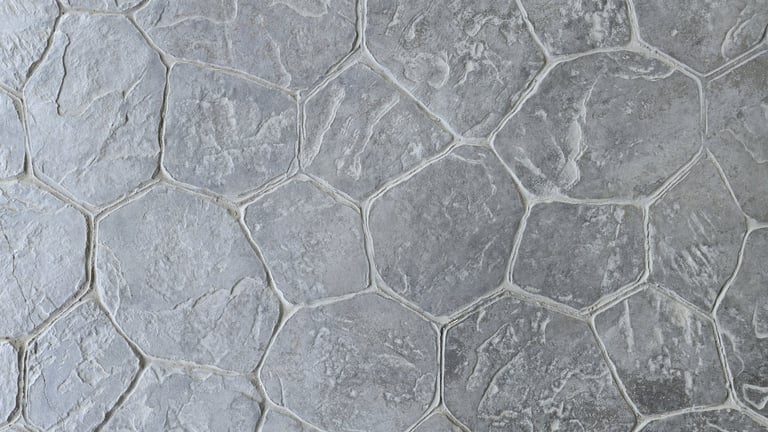 Natural grey stamped concrete with a random flagstone pattern and a rough, rugged surface
