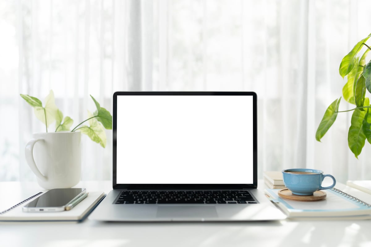 Workspace showing website design on laptop screen in a bright modern office