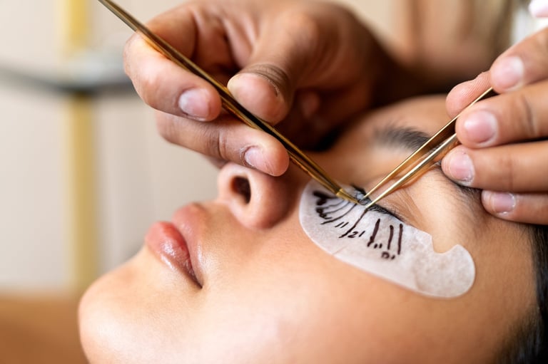Professional lash artist carefully applying individual eyelash extensions on a client