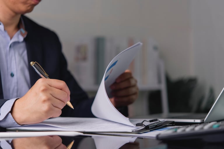 Empresario firmando contrato y revisando reporte financiero con asesor contable para regularizarse ante el SAT