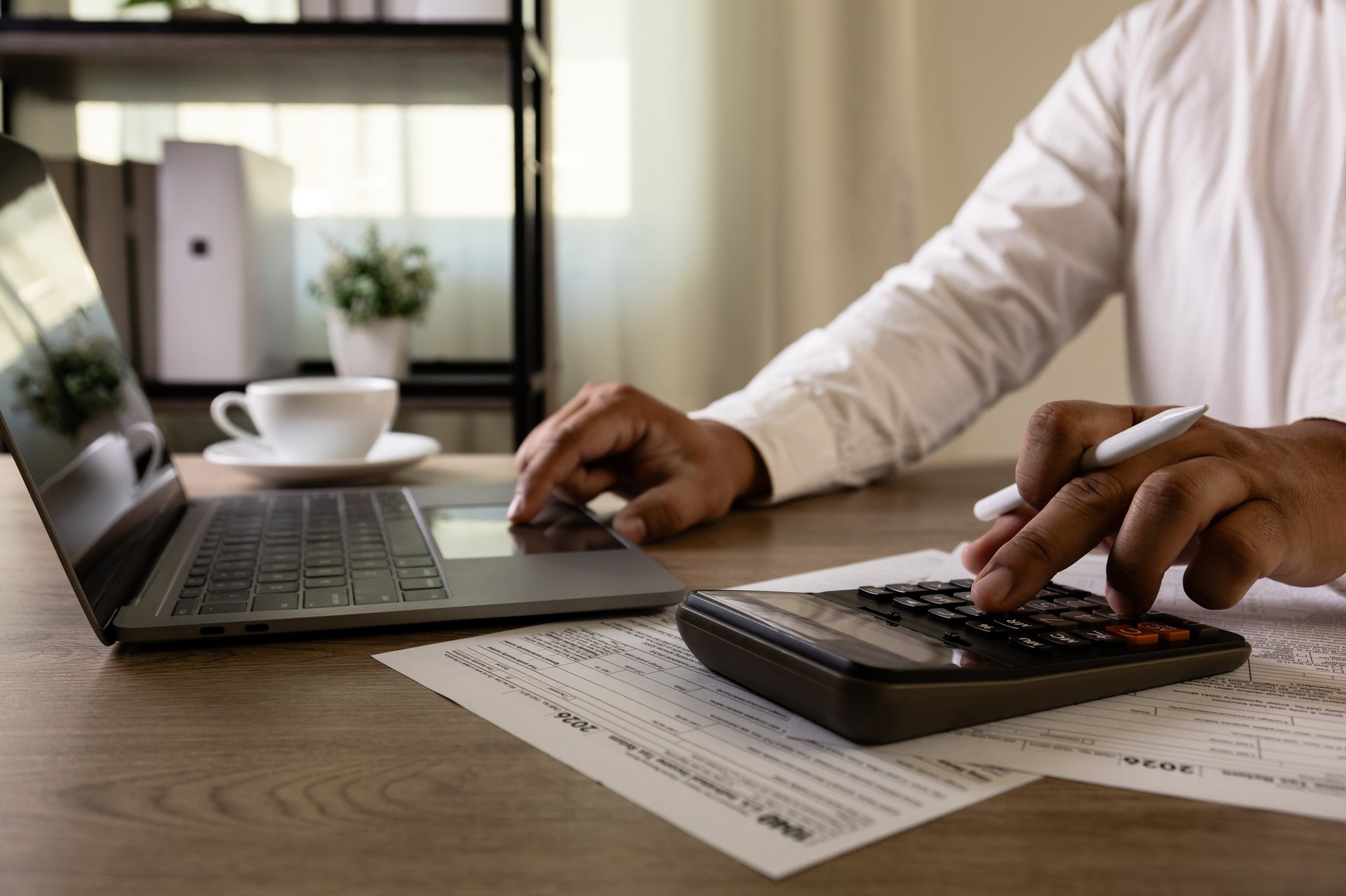 Accountant with US tax forms, calculator, tax papers, financial documents, tax filing preparation