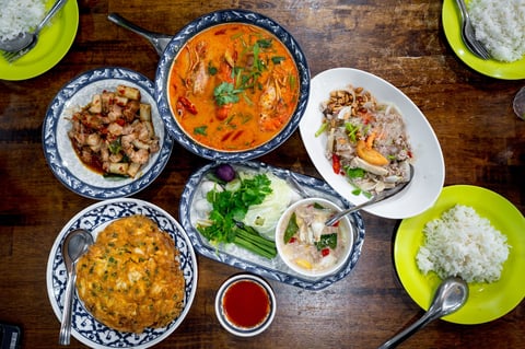 Various Thai dishes on wood table