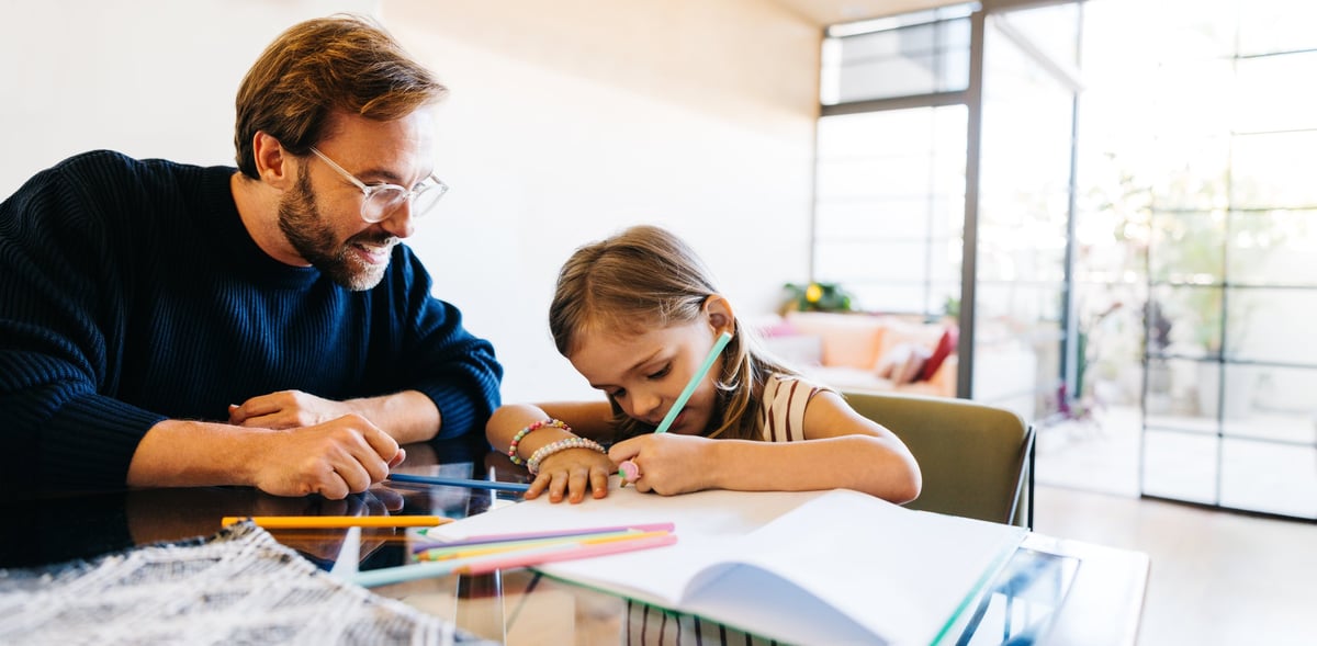 A parent guiding a child through focused learning activity at home for the PEP Hybrid program