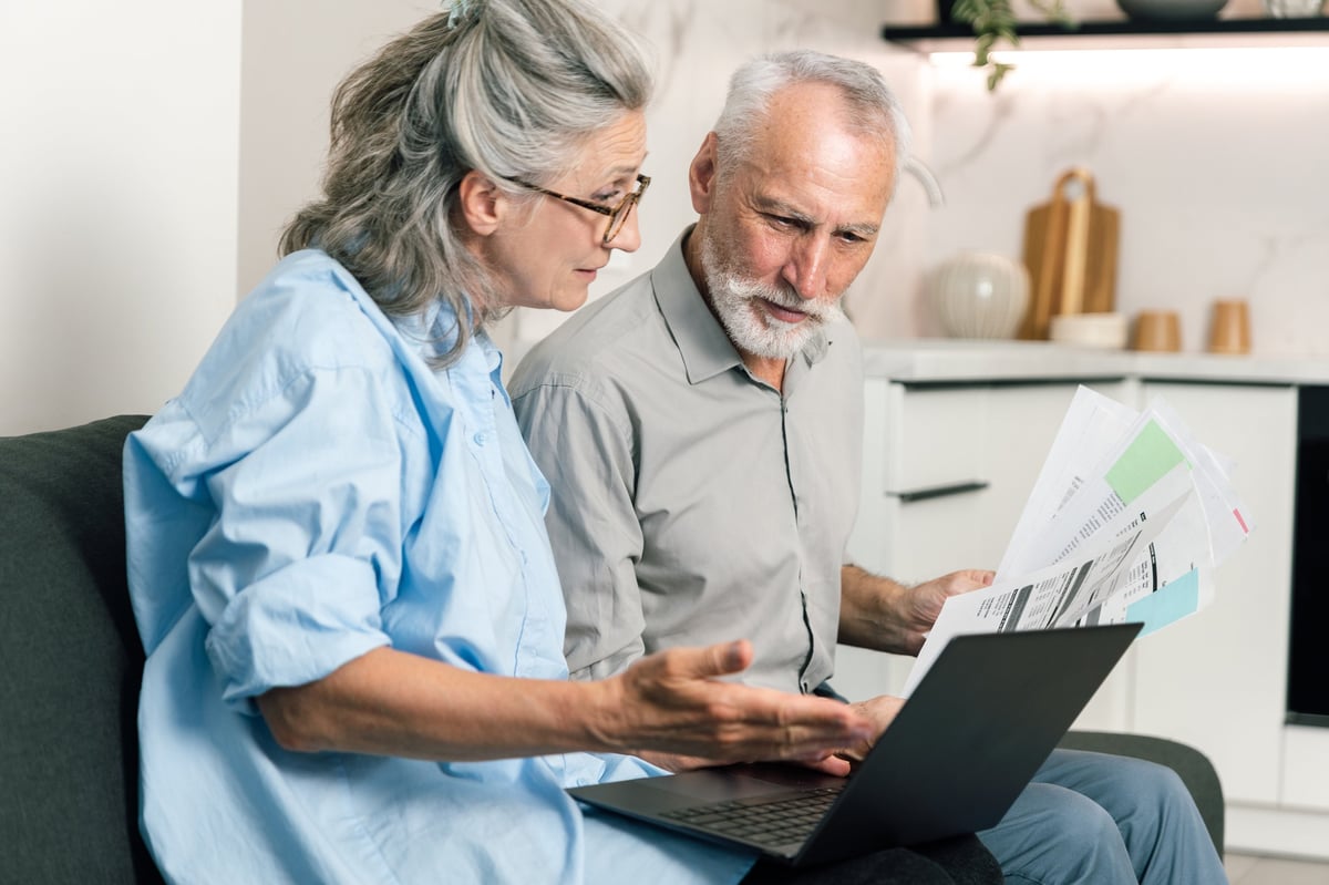 Couple reviewing refinance documents and budget together at home