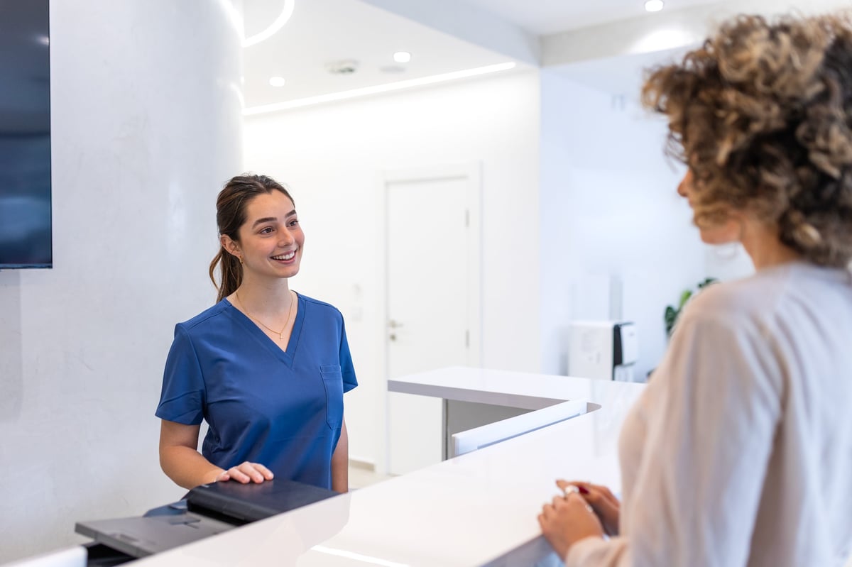 Friendly receptionist at River City Hearing welcoming patients at the clinic front desk in Peoria, Illinois
