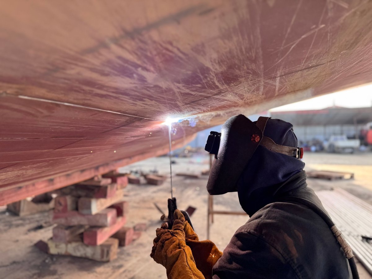 Welder working on ship repair in shipyard