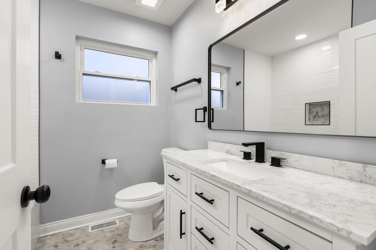 Modern white bathroom with marble countertop and black fixtures