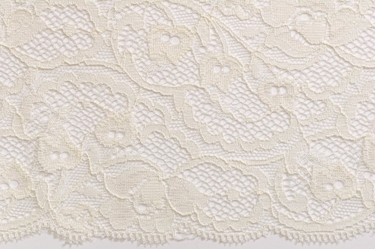 Elfenbein Spitzenbordüre mit floralem Muster auf weißem Hintergrund — elegante textile Verzierung