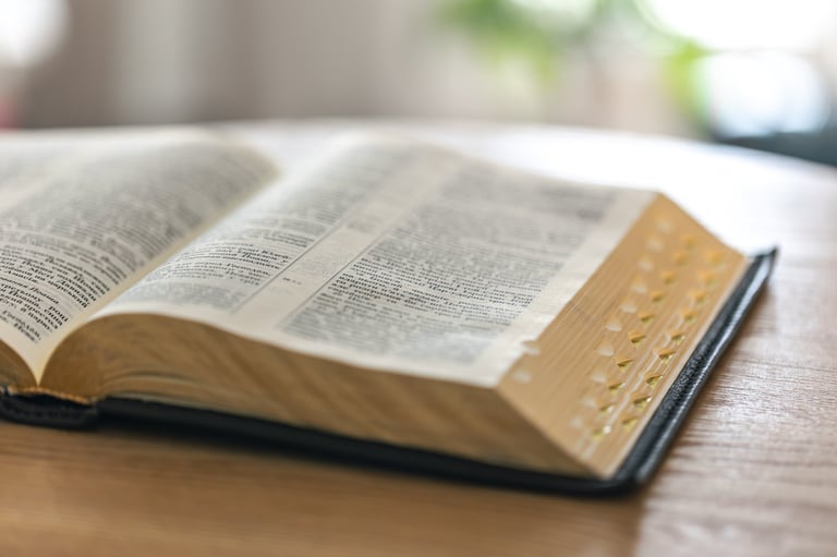 An open Bible with golden edges on a wooden table