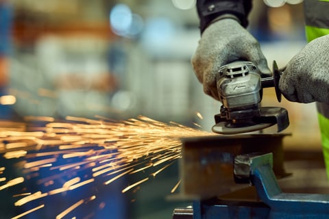 Factory worker grinding metal