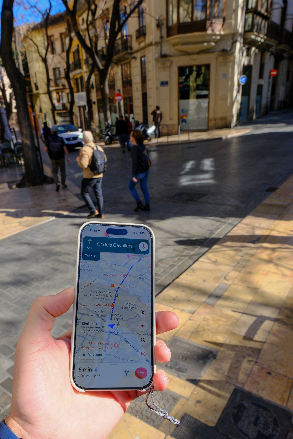 Person using a mobile phone map navigation tool to locate a business in town