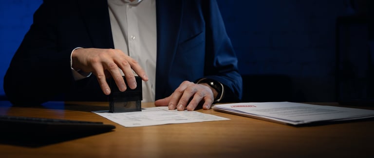 Businessman stamping documents in dark office