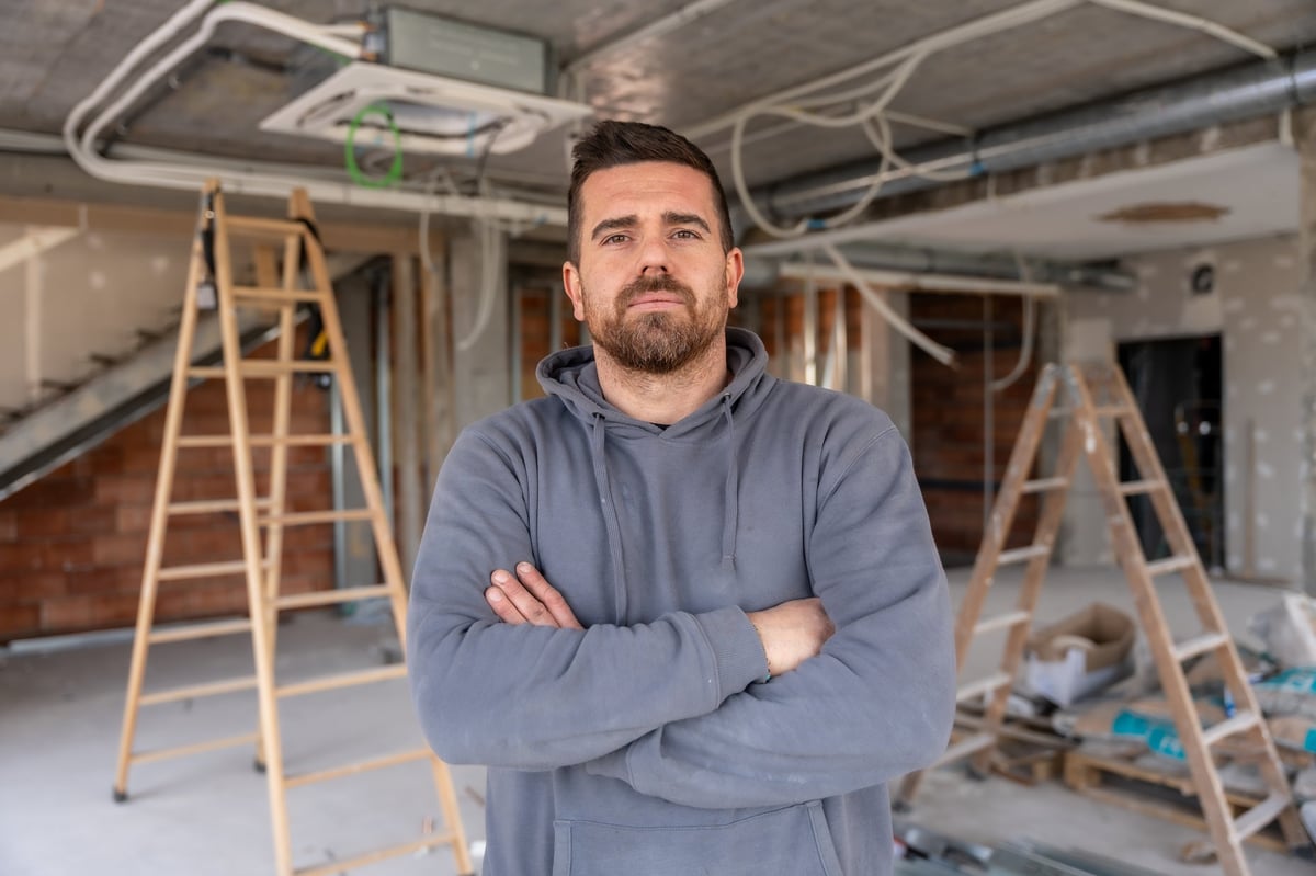 Contractor at construction site reviewing air conditioning installation in the ceiling