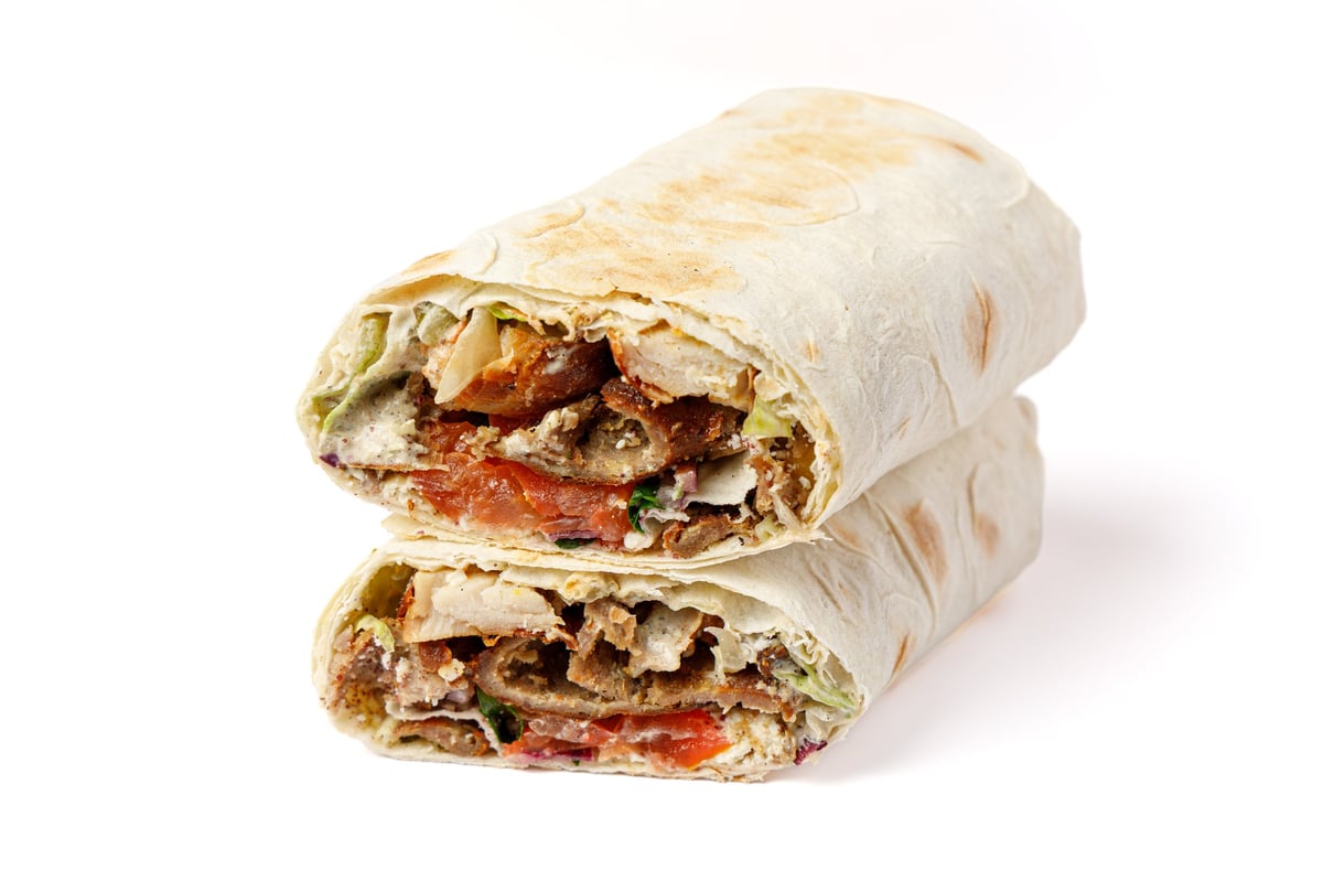 Two neatly stacked burrito halves showing colorful filling of vegetables and seasoned meat