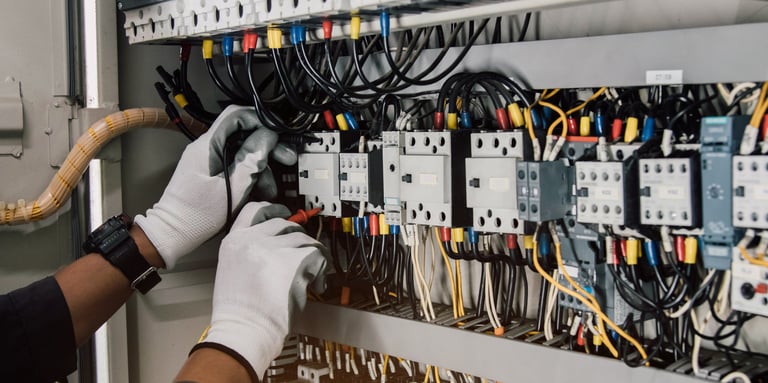 Electrician engineer tests electrical installations and wires on relay protection system