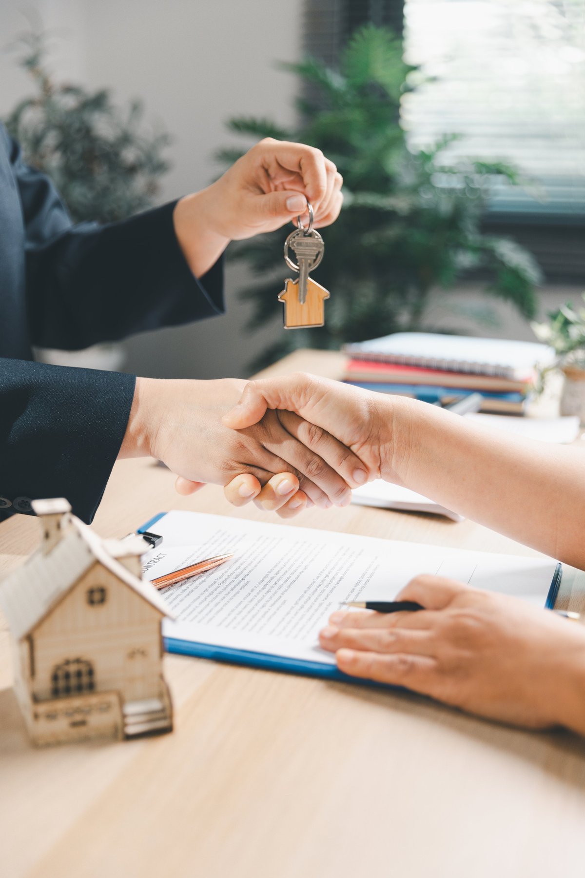 Couple shaking hands with their lender after receiving mortgage approval