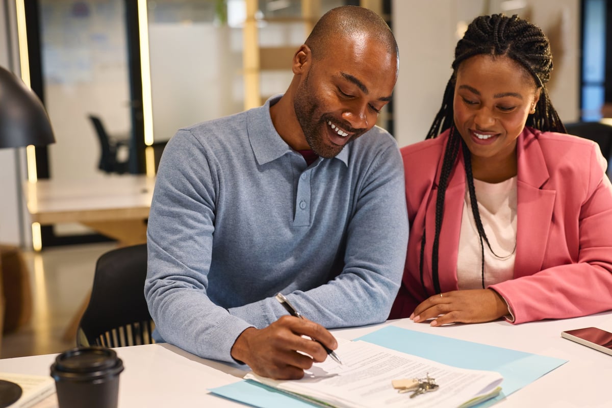 Couple signing their mortgage paperwork for a new home