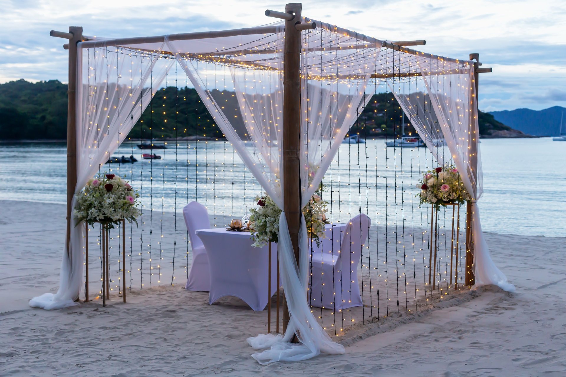Beautifully arranged romantic outdoor setup with floral decorations, fairy lights, and an intimate dreamy atmosphere