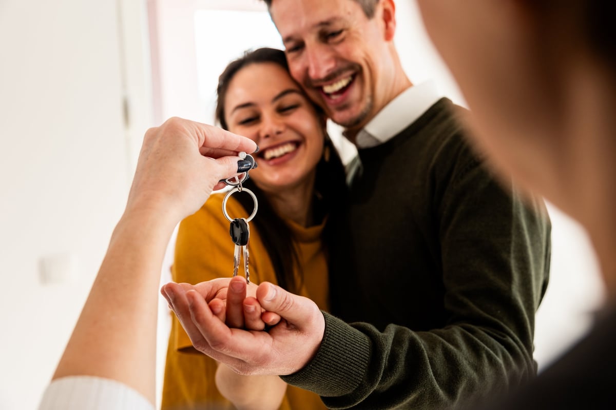Smiling couple reviewing paperwork with a loan officer before closing