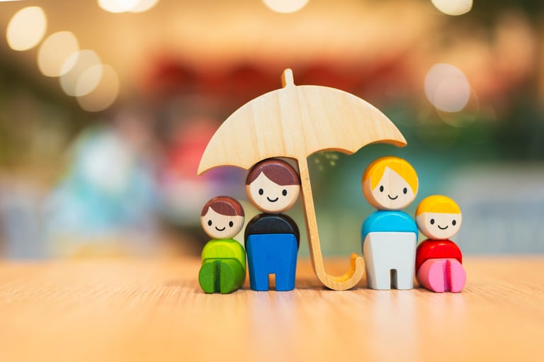 Wooden family figures under umbrella representing life insurance protection