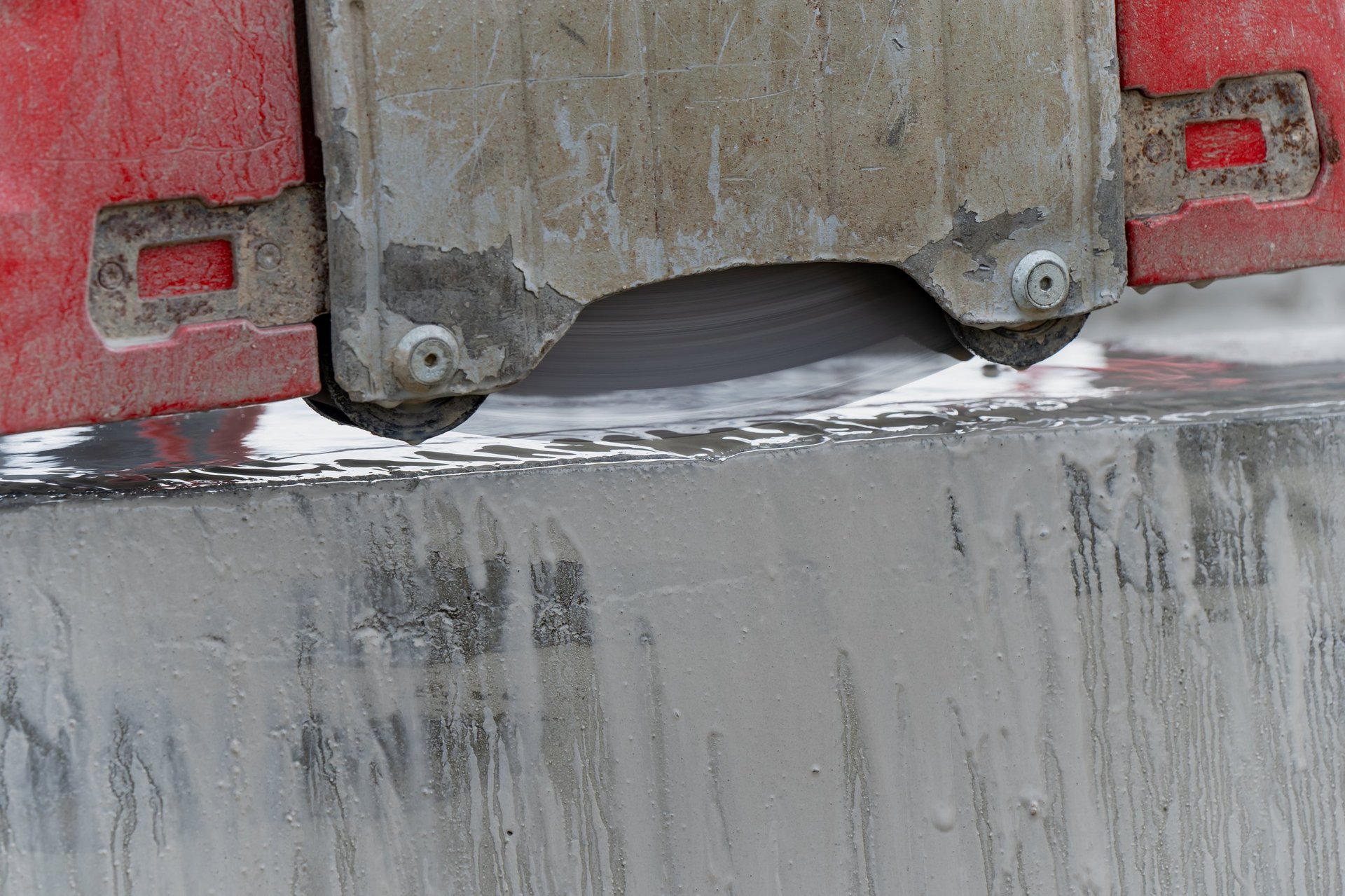 Concrete wall saw blade cutting wet slab edge with cooling water