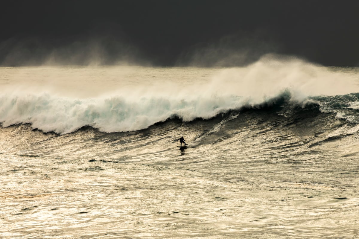 Surfer riding a perfect barrel at sunrise