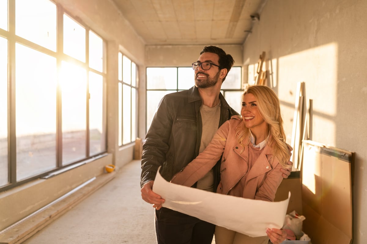 Couple reviewing home renovation plans together at a table
