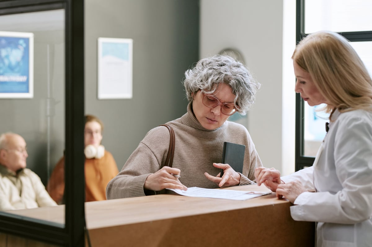 Senior woman working with River City Hearing staff to understand insurance coverage for hearing aids in Peoria, Illinois