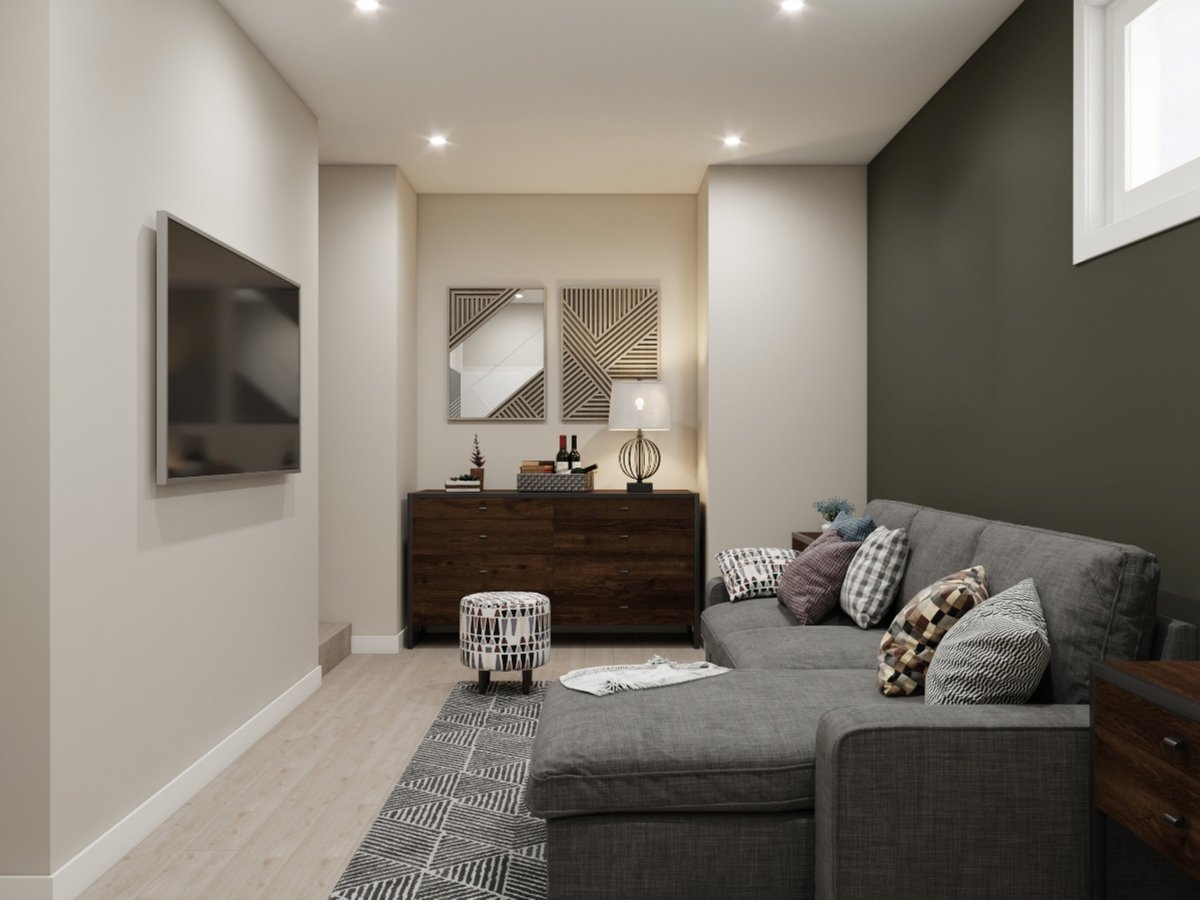 Contemporary basement living room featuring gray sofa with patterned cushions and television mounted on wall
