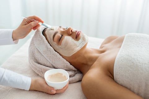 Esteticista profesional aplicando tratamiento facial en spa