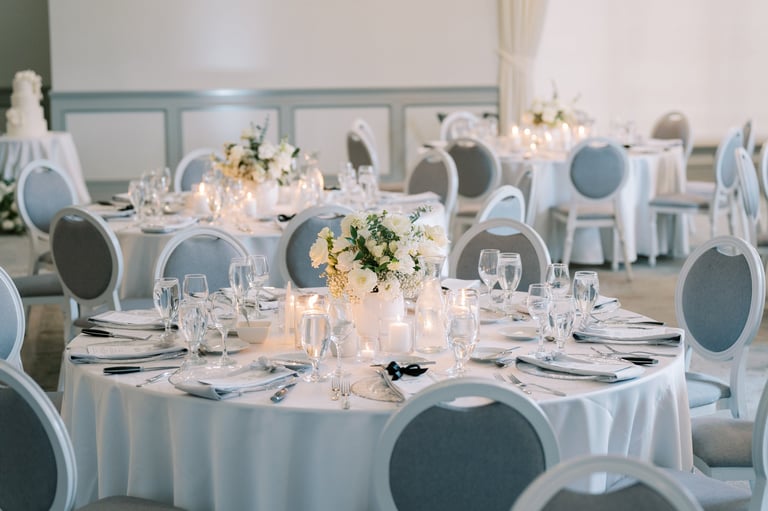 Elegant banquet hall set for reception with round tables and floral centerpieces