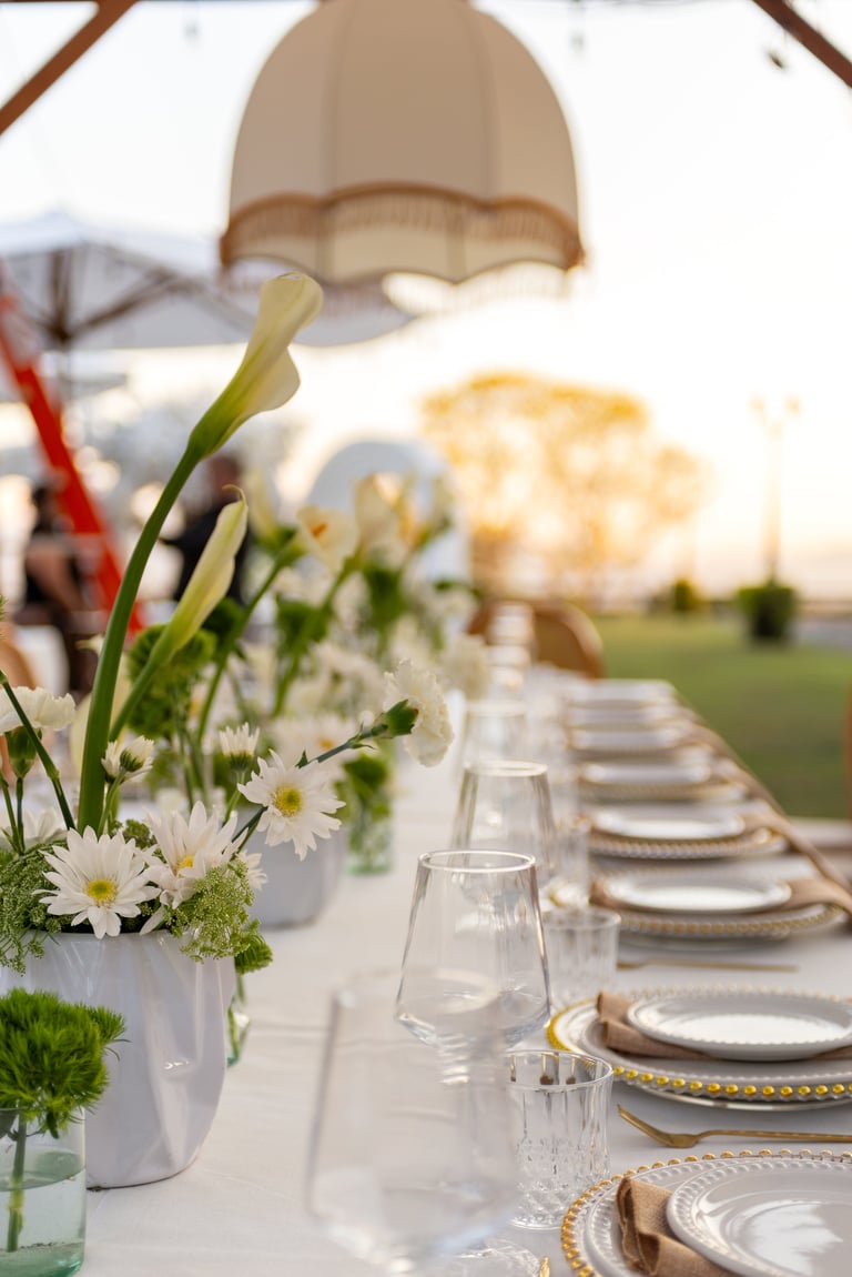 Elegant outdoor wedding dinner table with white floral centerpieces
