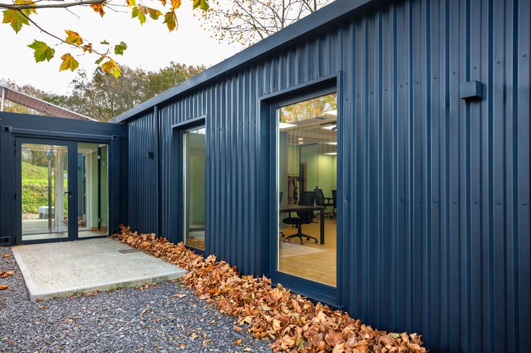 Contemporary modular office pod built from a shipping container with corrugated metal facade and large glazed windows