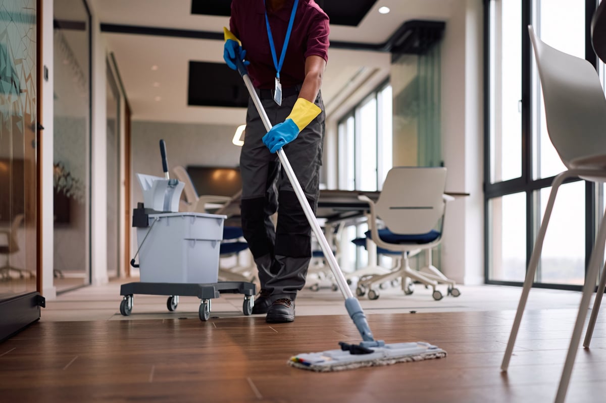 Professional office cleaner mopping floors after hours