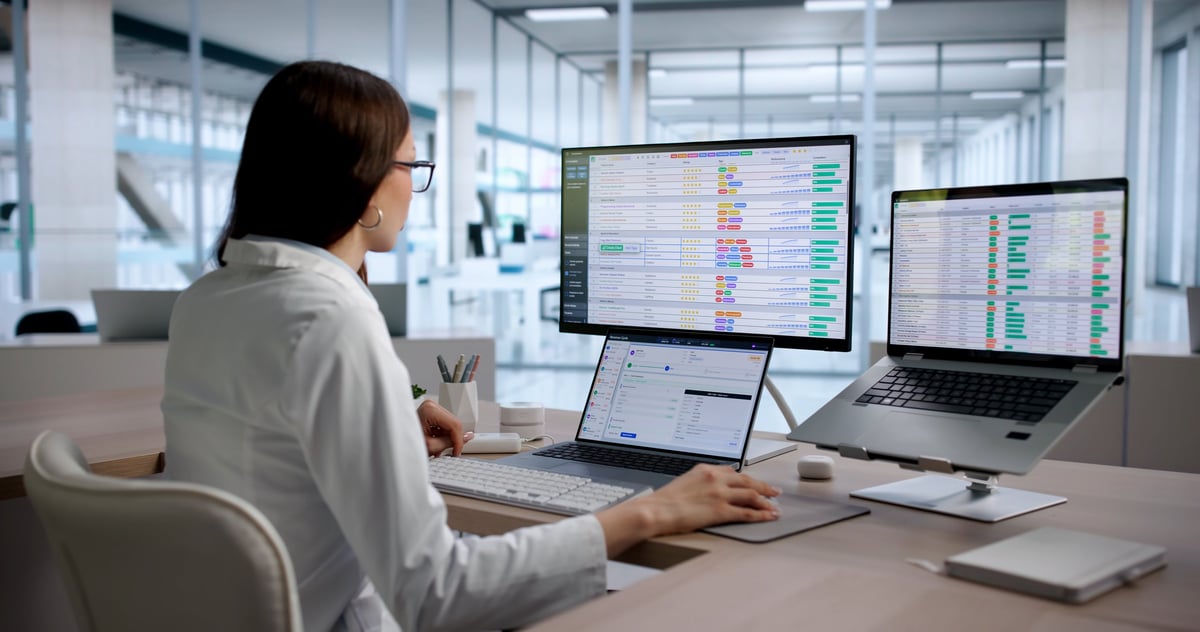 Healthcare administrator reviewing revenue cycle management reports and medical billing data for cost reduction opportunities