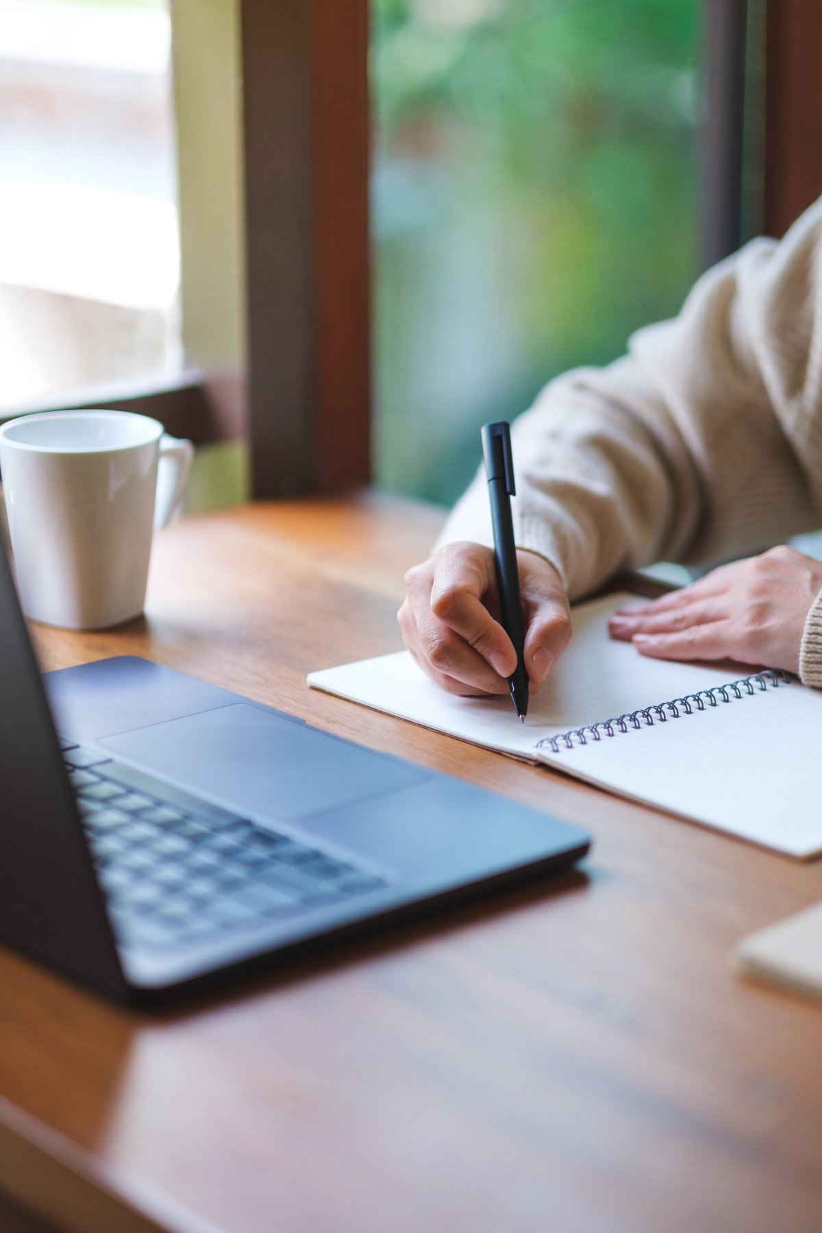 Woman writing notes while working at home — a quiet moment of planning the next chapter