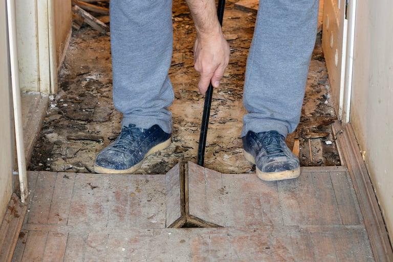Professional demolition worker dismantling parquet floor