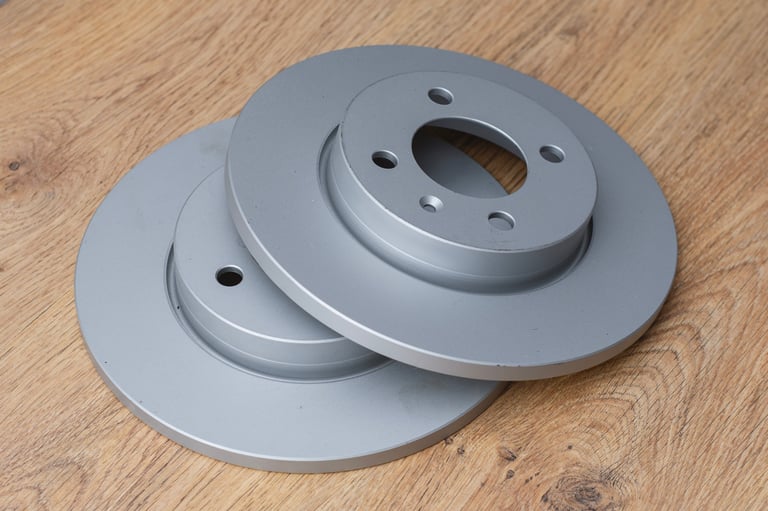 New silver brake disc rotors on wooden workbench