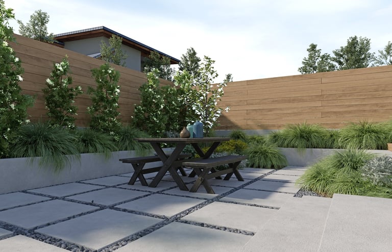 3D render of a modern backyard patio with wooden picnic table, concrete pavers with pebbles, lush green plants, and wooden fence