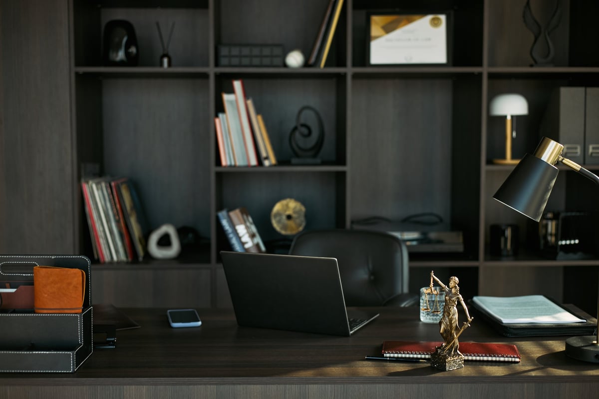 Lawyer office desk with legal files and justice statue