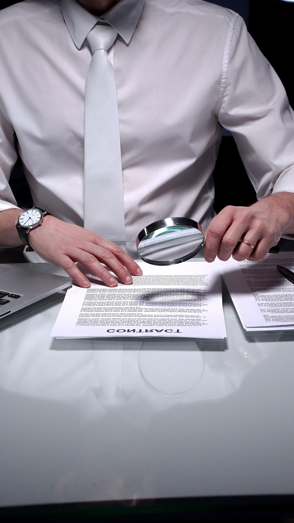 Business person closely examining a contract document with a magnifying glass, highlighting the importance of understanding lease fine print