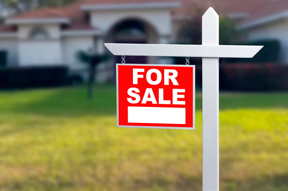 Neighborhood home with a for sale sign representing a short sale