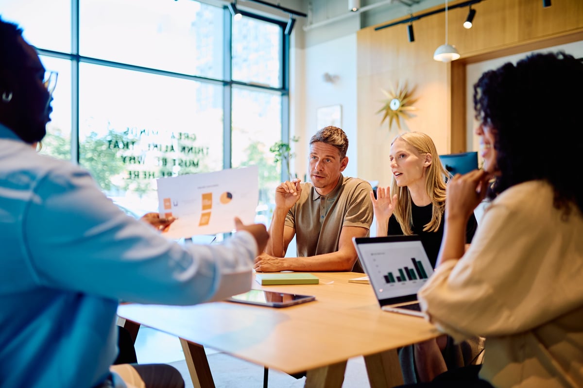 Startup team collaborating around a laptop in a modern office