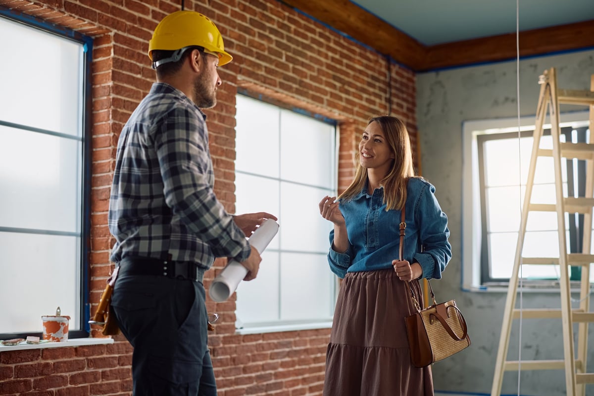 Homeowner communicating with construction worker during home remodeling project
