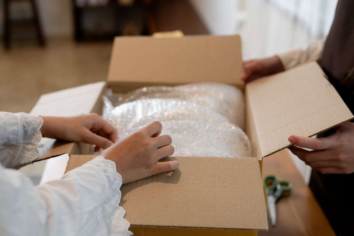 Sorgfältig mit Luftpolsterfolie verpackte empfindliche Gegenstände im Umzugskarton — Schutz für wertvolle Erinnerungsstücke